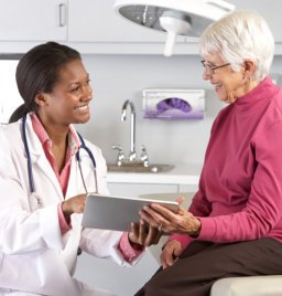 doctor shows tablet to elder woman